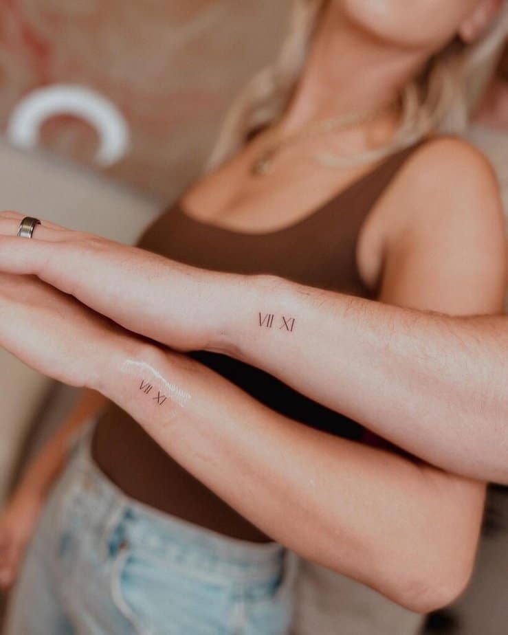 Matching wrist tattoos of Roman numerals