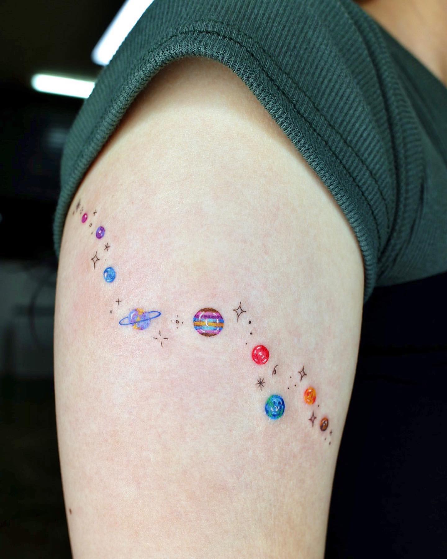 Minimal Color Cartoon Tattoo of Planets on Arm