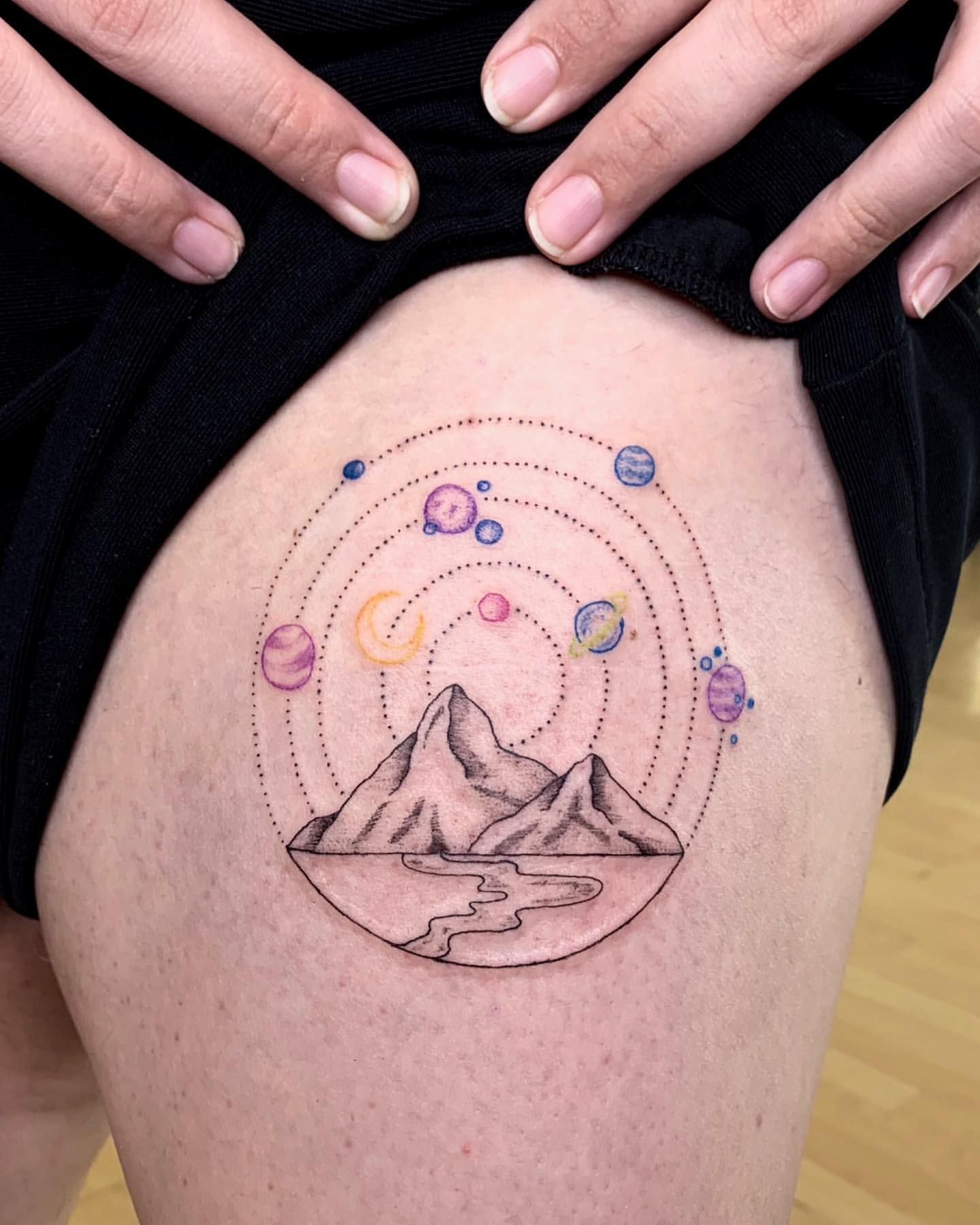 Minimal Thigh Tattoo of Planets Above Mountain Tops