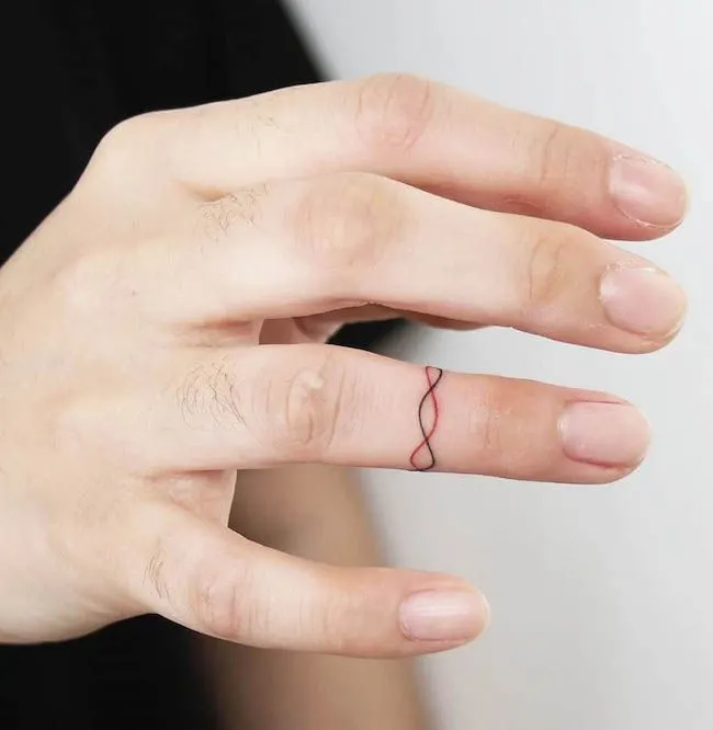 A dual color string tattoo on the ring finger