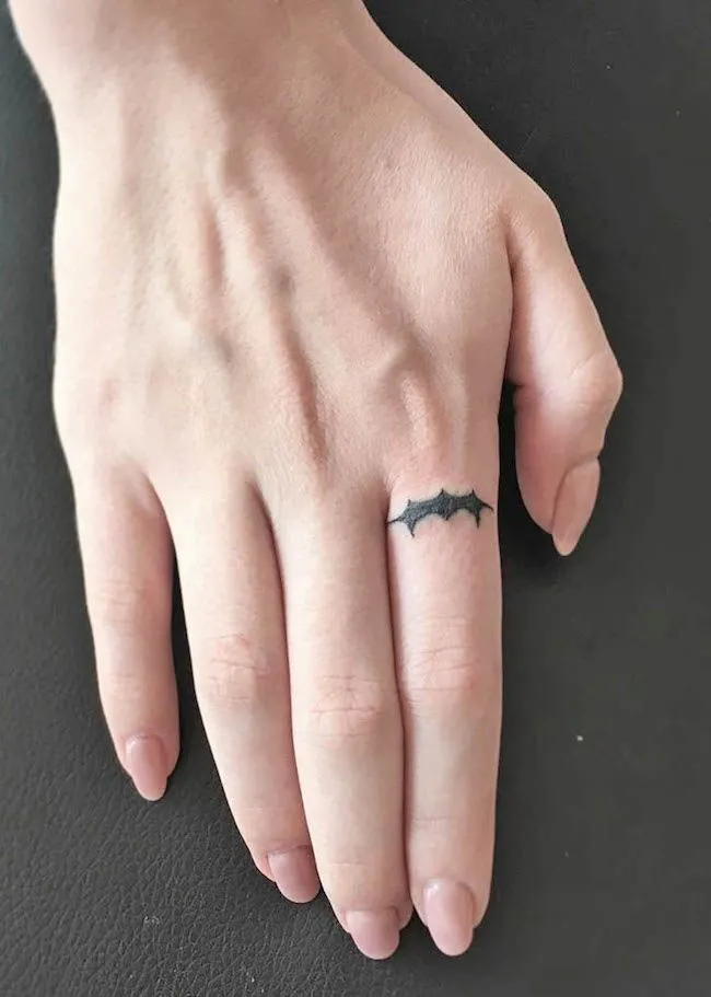 A small Batman tattoo on the index finger