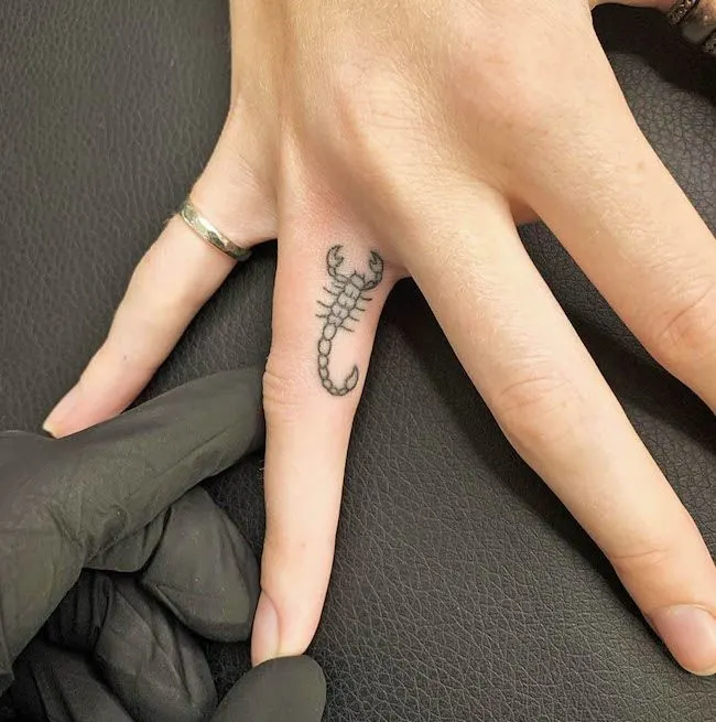 A small Scorpio finger tattoo