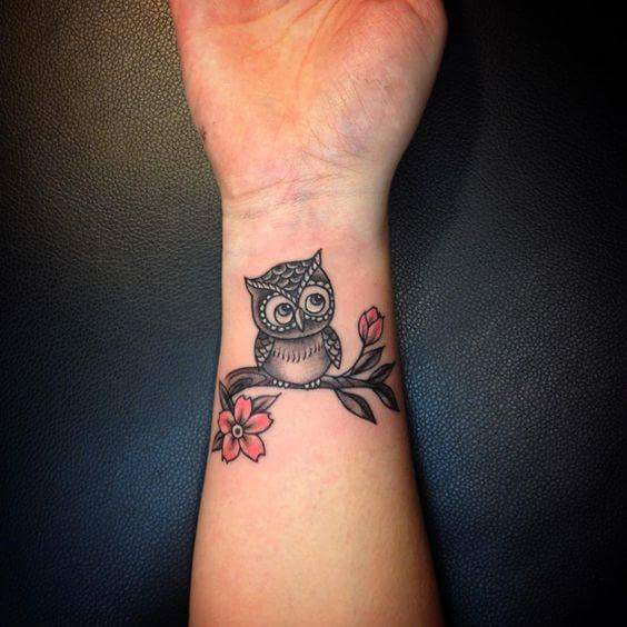 Tiny Owl Sitting On Branch With Red Flowers Tattoo