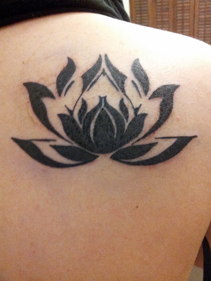 black lotus flower tattoo on shoulder blade