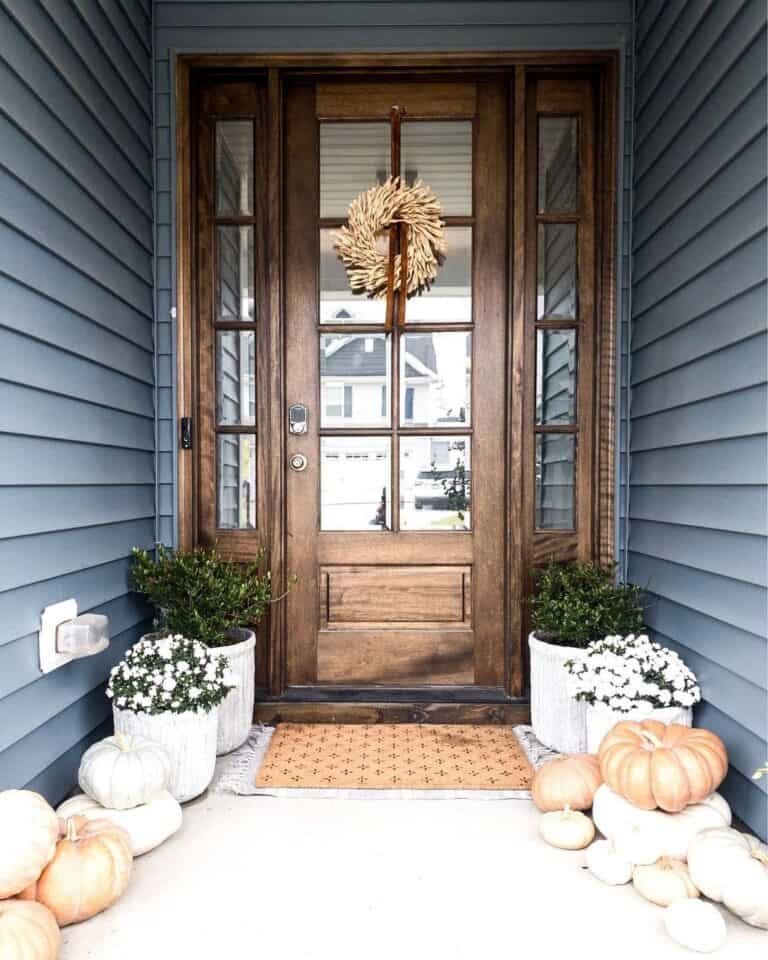 From Simple to Showstopper: 25 Easy Fall Door Decor Ideas 9 Dark Blue Exterior with Pumpkins